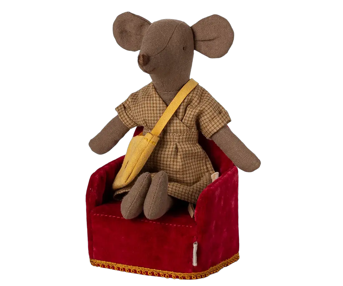 Maileg mouse doll in a brown checked dress sits on a red velvet chair with a yellow crossbody bag