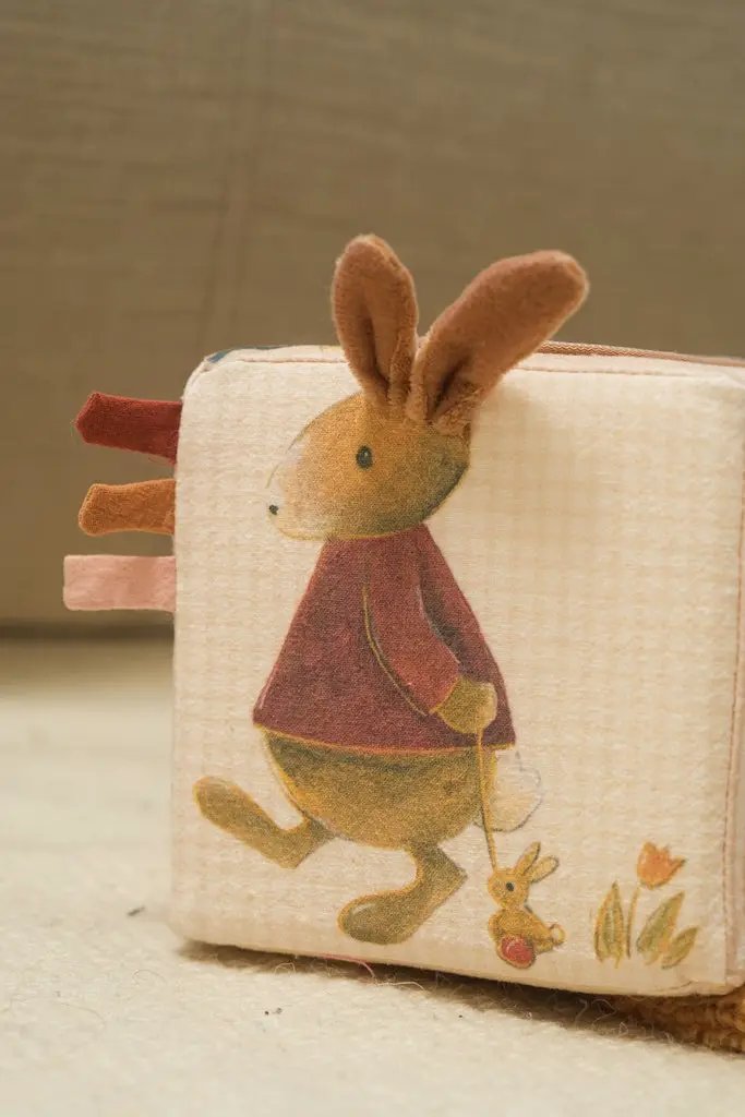 Cube d'activités Citron Grenadine en tissu beige avec un lapin et rubans colorés