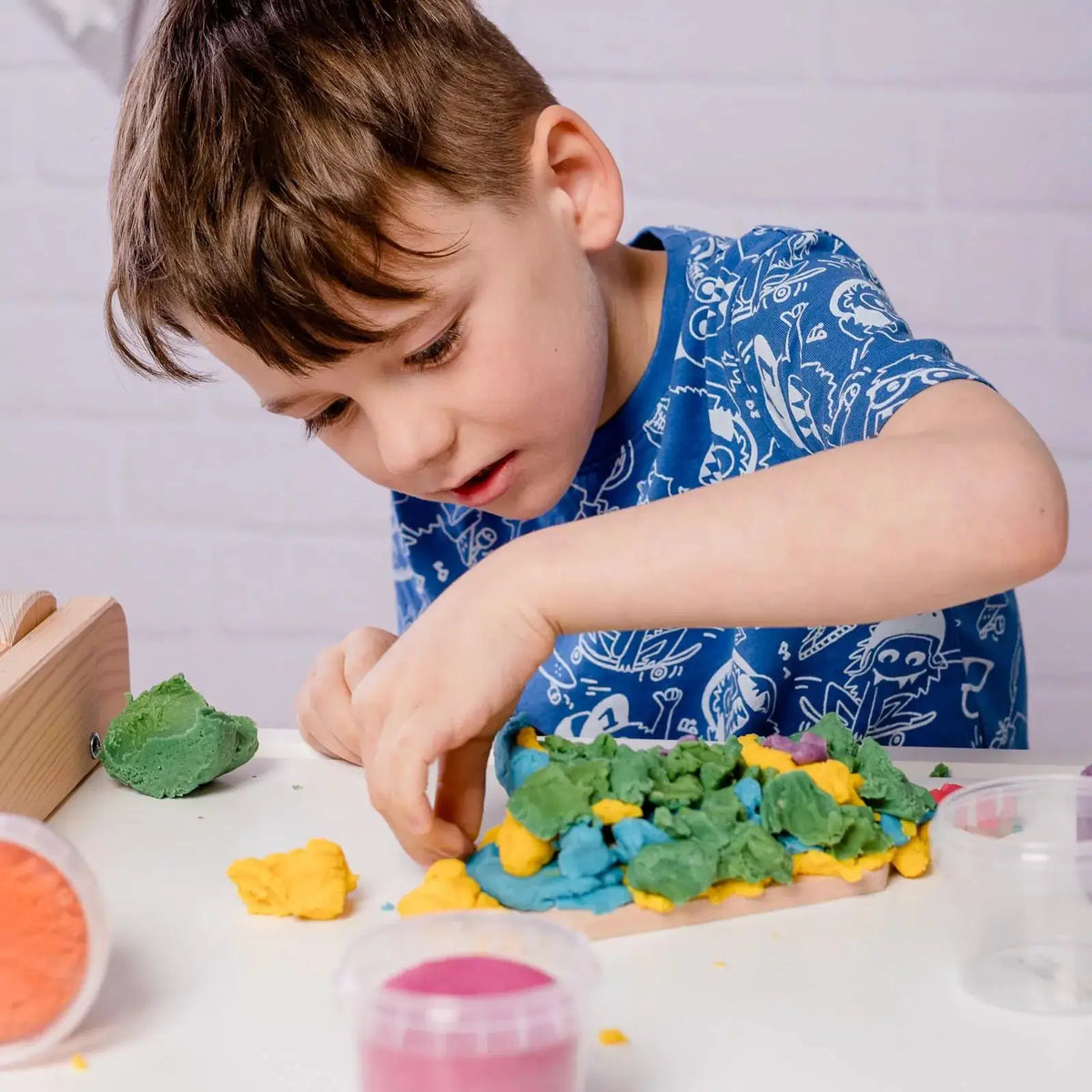 Pâte à modeler végan bio NEOGRÜN set Loki par Citron Grenadine, enfant manipulant des couleurs multicolores.