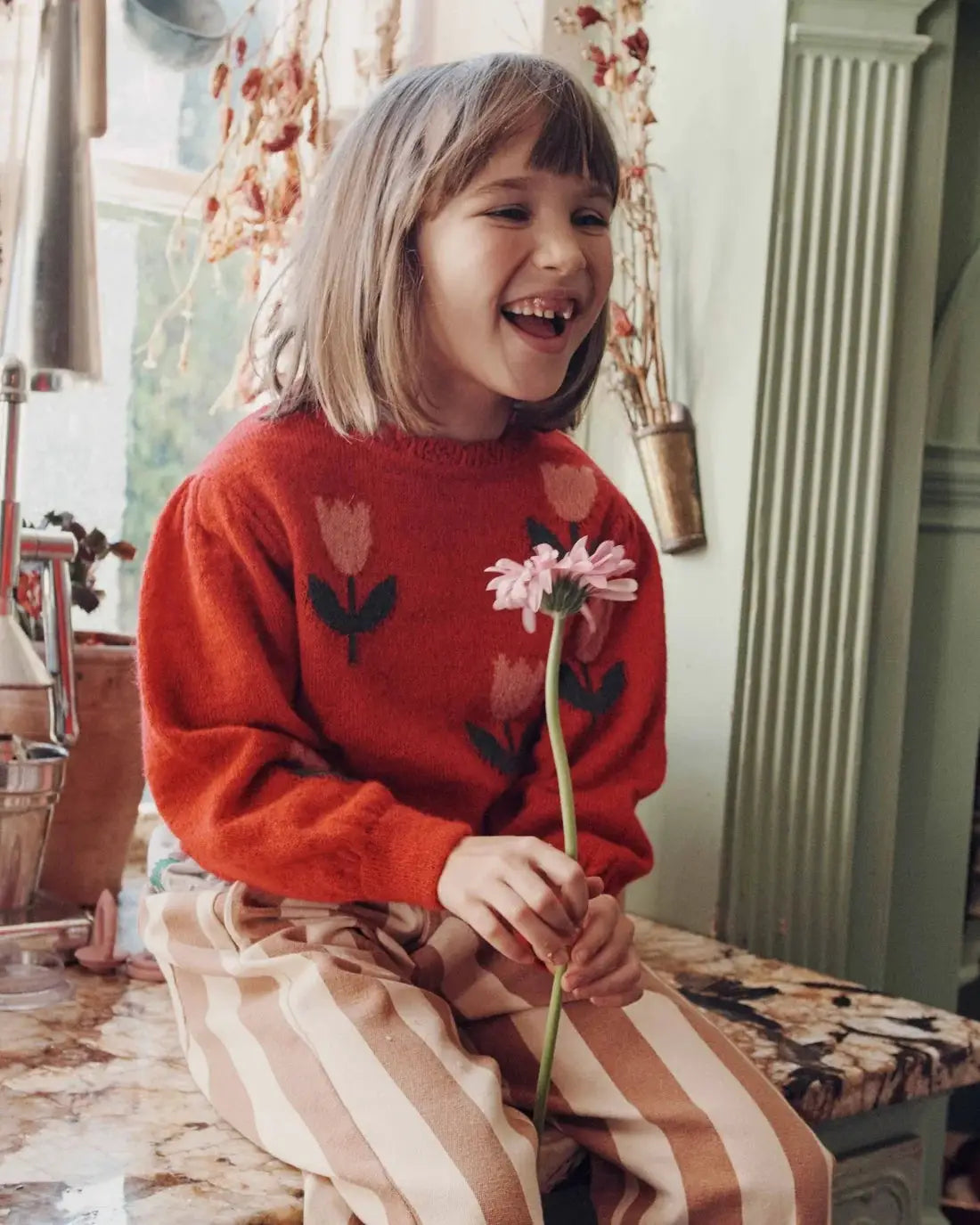 Emile et Ida pull intarsia tulipe mars red knit pullover worn by girl with pink flower.
