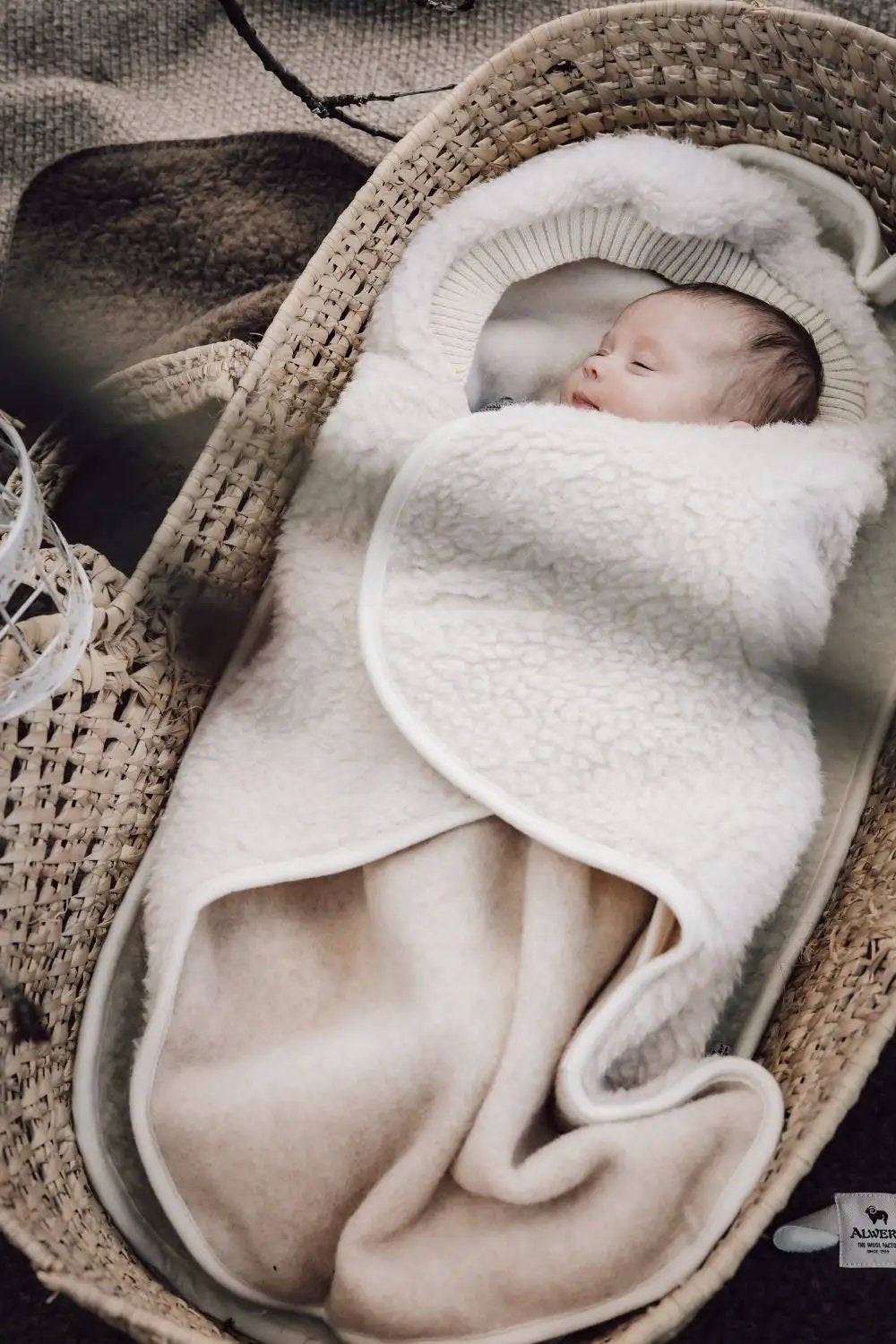 ALWERO nid d'ange en laine beige avec bébé dans un couffin en osier