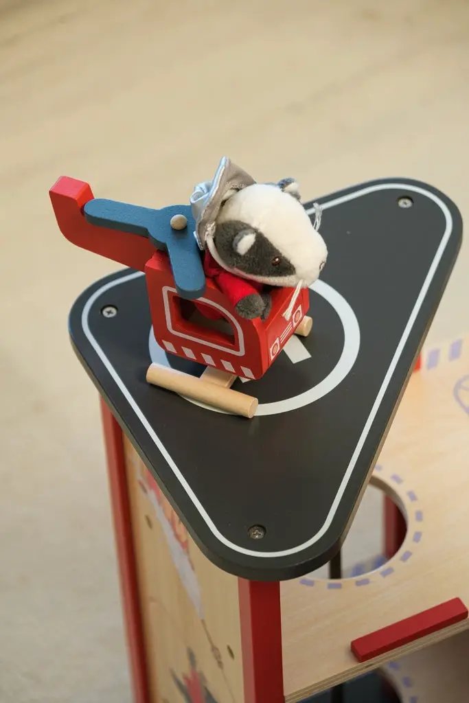 EGMONT TOYS caserne des pompiers en bois; petit hélicoptère rouge et bleu avec peluche gris sur toit noir