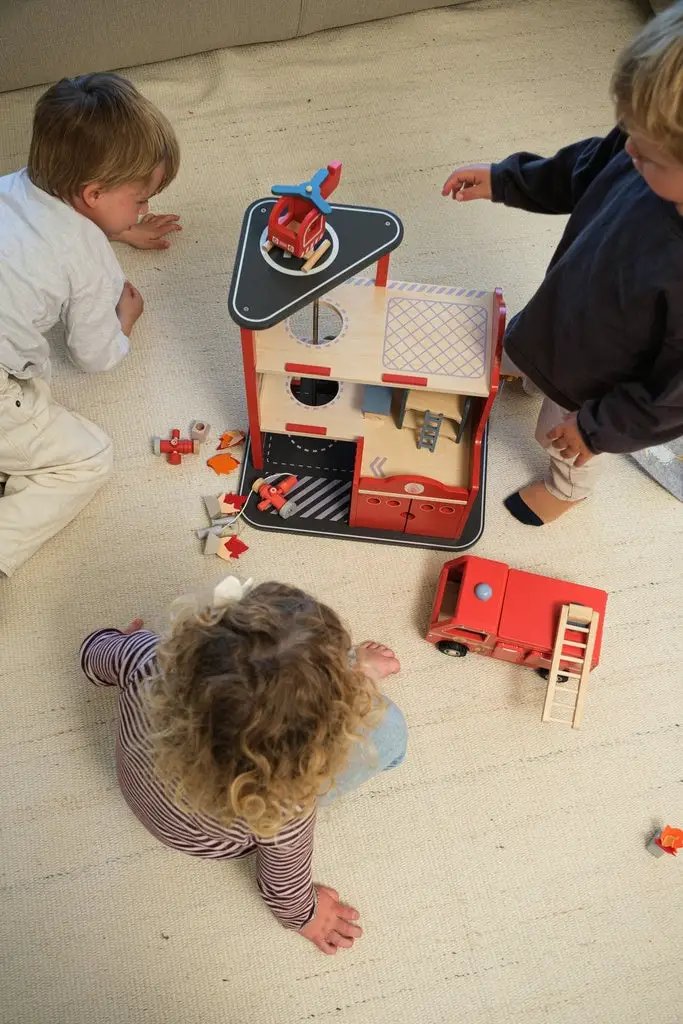 EGMONT TOYS caserne des pompiers en bois avec petit camion rouge et accessoires sur tapis beige