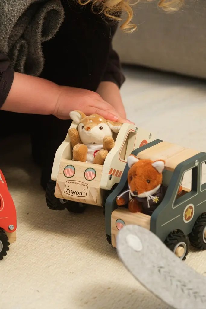 Two wooden Egmont Toys trucks with plush animals in the cargo beds; green and cream finishes.