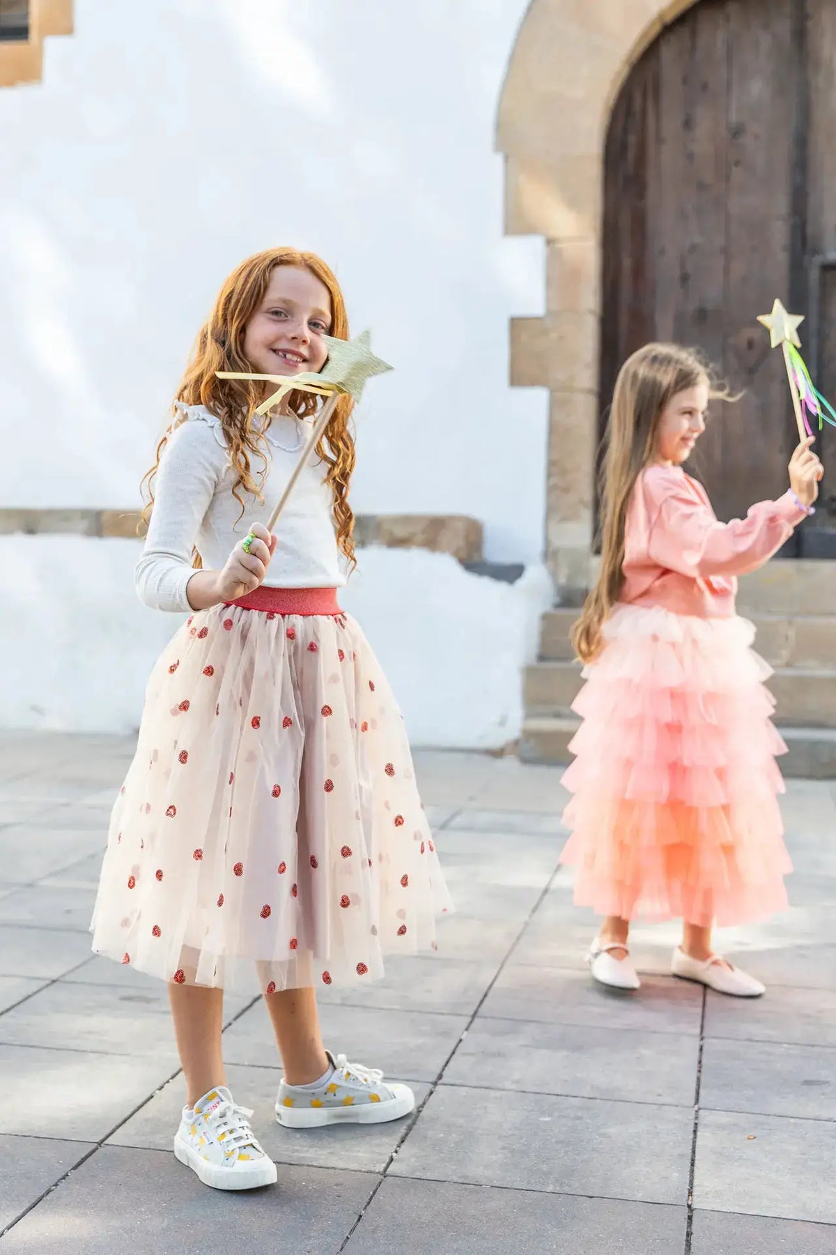 RATATAM jupon célestine beige à coeurs rouges en tulle pour enfants; deux jeunes filles portent des jupes pastel.
