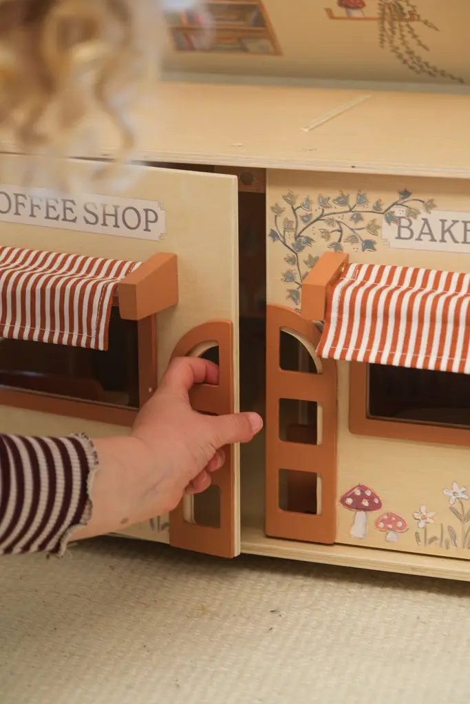 Café et boulangerie en bois EGMONT TOYS; portes orange ouvertes, auvents rayés et décor champêtre
