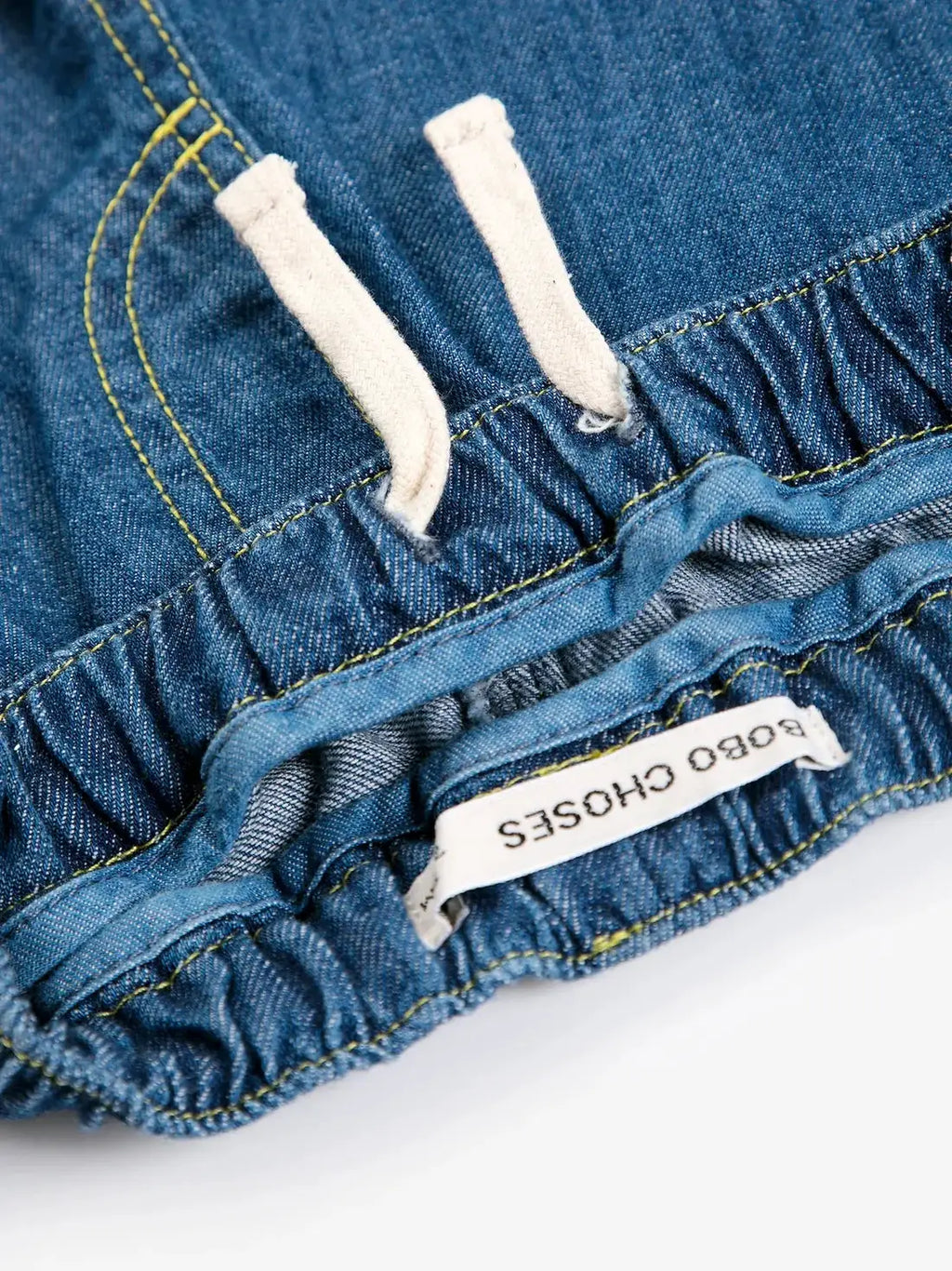 BOBO CHOSES denim pantalon with elastic waist and white drawstrings; blue denim with yellow stitching, brand tag.