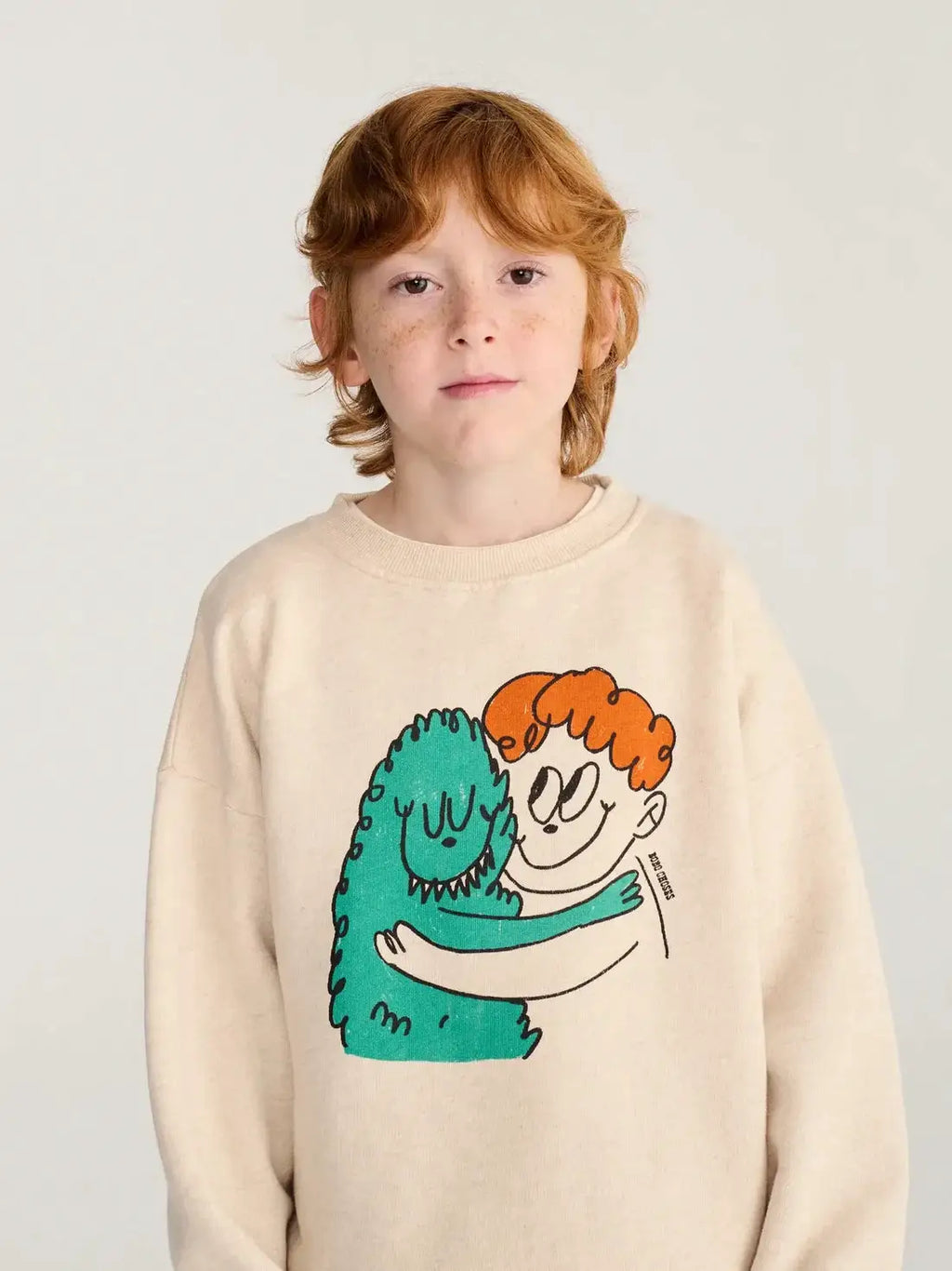 BOBO CHOSES hug hairy monster sweatshirt, beige with a green monster hugging an orange-haired boy