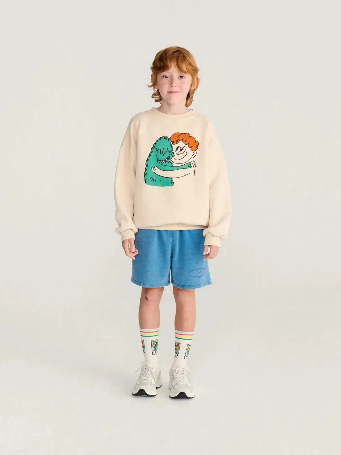 BOBO CHOSES hug hairy monster sweatshirt, beige with teal monster hugging an orange-haired child