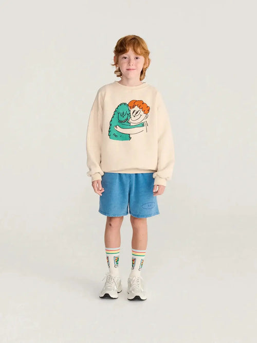 BOBO CHOSES hug hairy monster sweatshirt, beige with teal monster hugging an orange-haired child