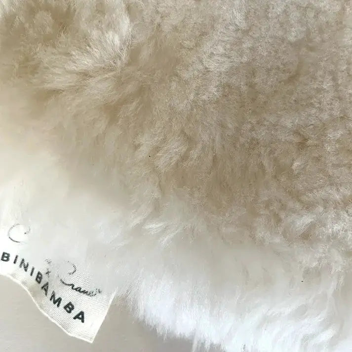 Peau de mouton Charlie Crane pour transat Levo, blanc crème, texture fluffy; étiquette Citron Grenadine visible