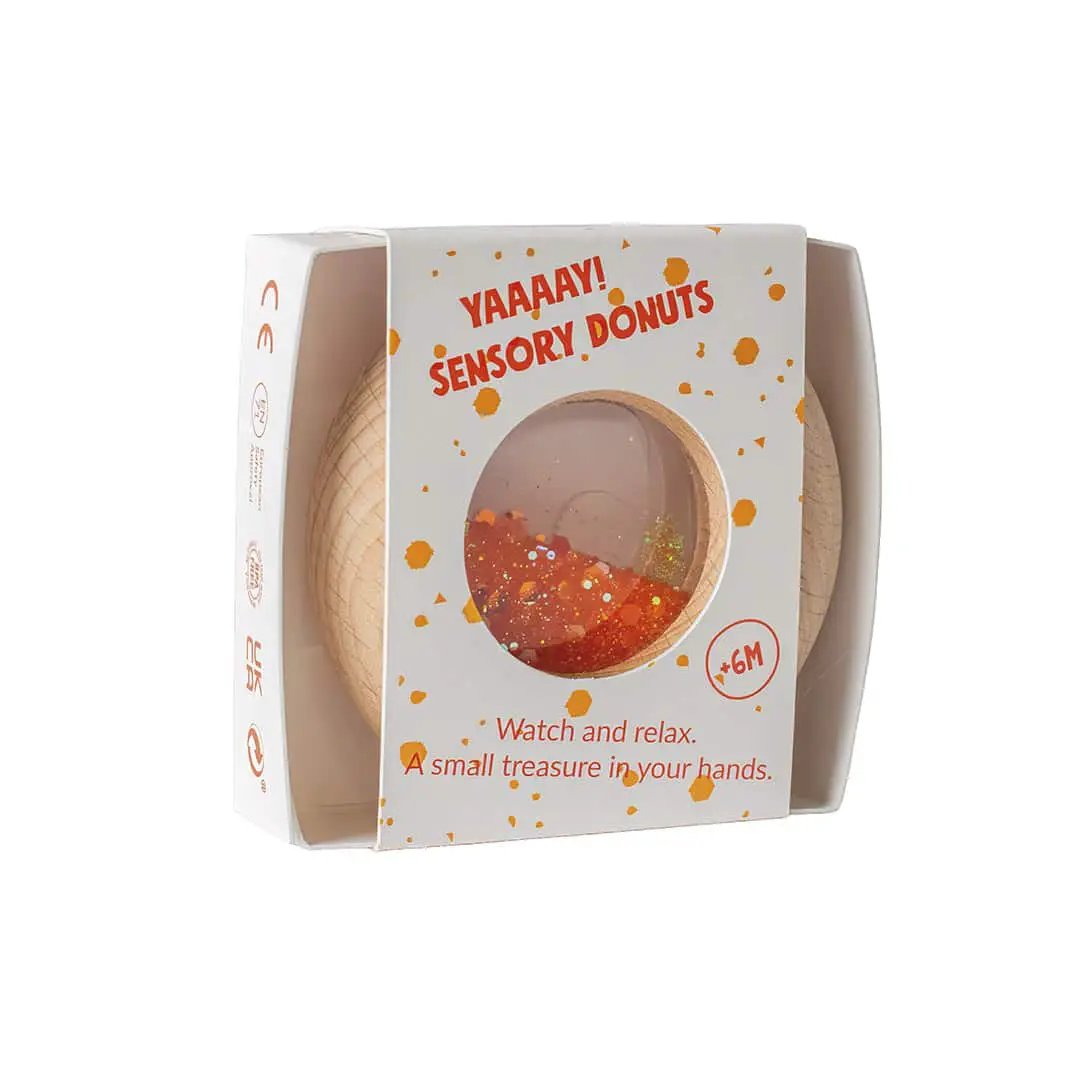 Petit Boum donut sensoriel orange teething toy by Citron Grenadine in white packaging with orange confetti.
