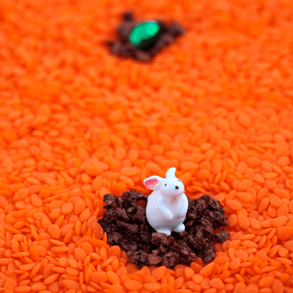 Bouteille sensorielle Petit Boum avec lapin blanc sur socle brun, jouet d’éveil pour bébé