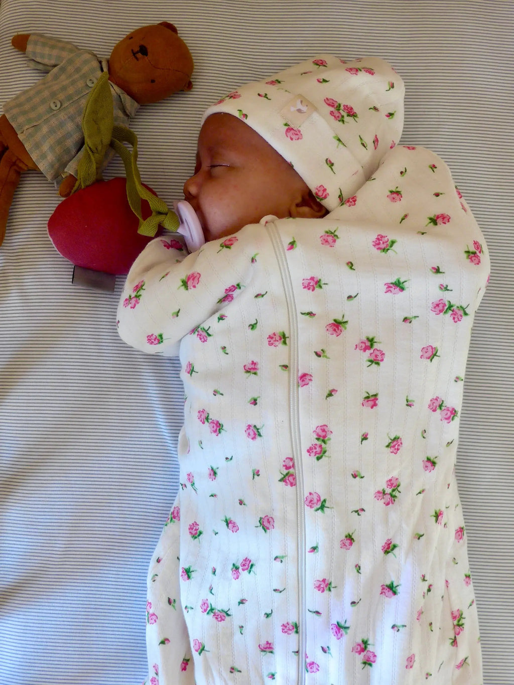 Emmailloteuse bloom swaddle blanket by Citron Grenadine; white with pink roses, on sleeping baby