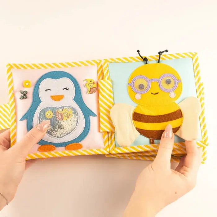 JOLLY DESIGNS livre d'éveil bébé; deux pages pelucheuses avec pingouin et abeille, cadre jaune rayé