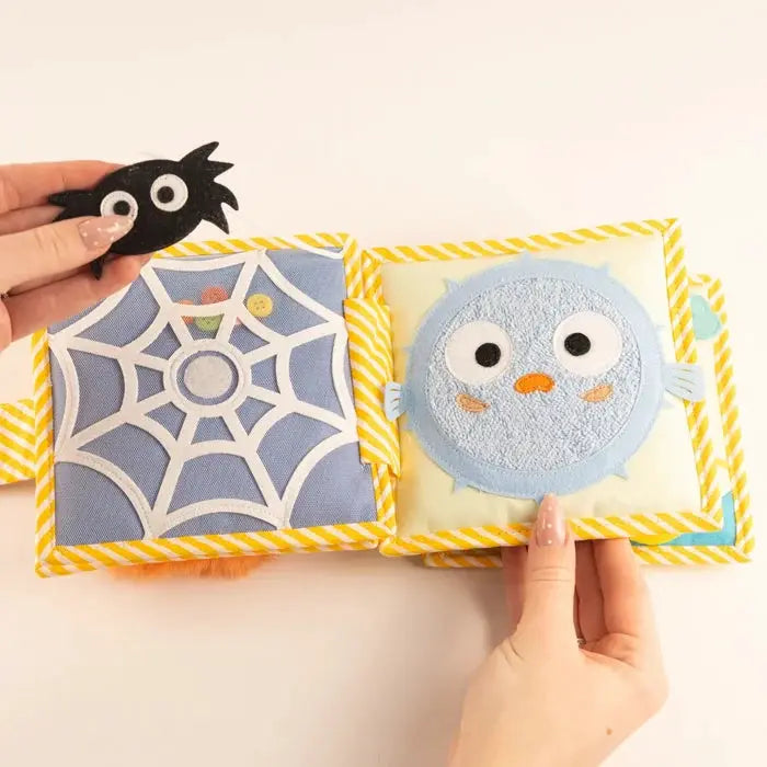 Livre d'éveil en tissu JOLLY DESIGNS avec pages bleu clair et motif araignée et monstre bleu