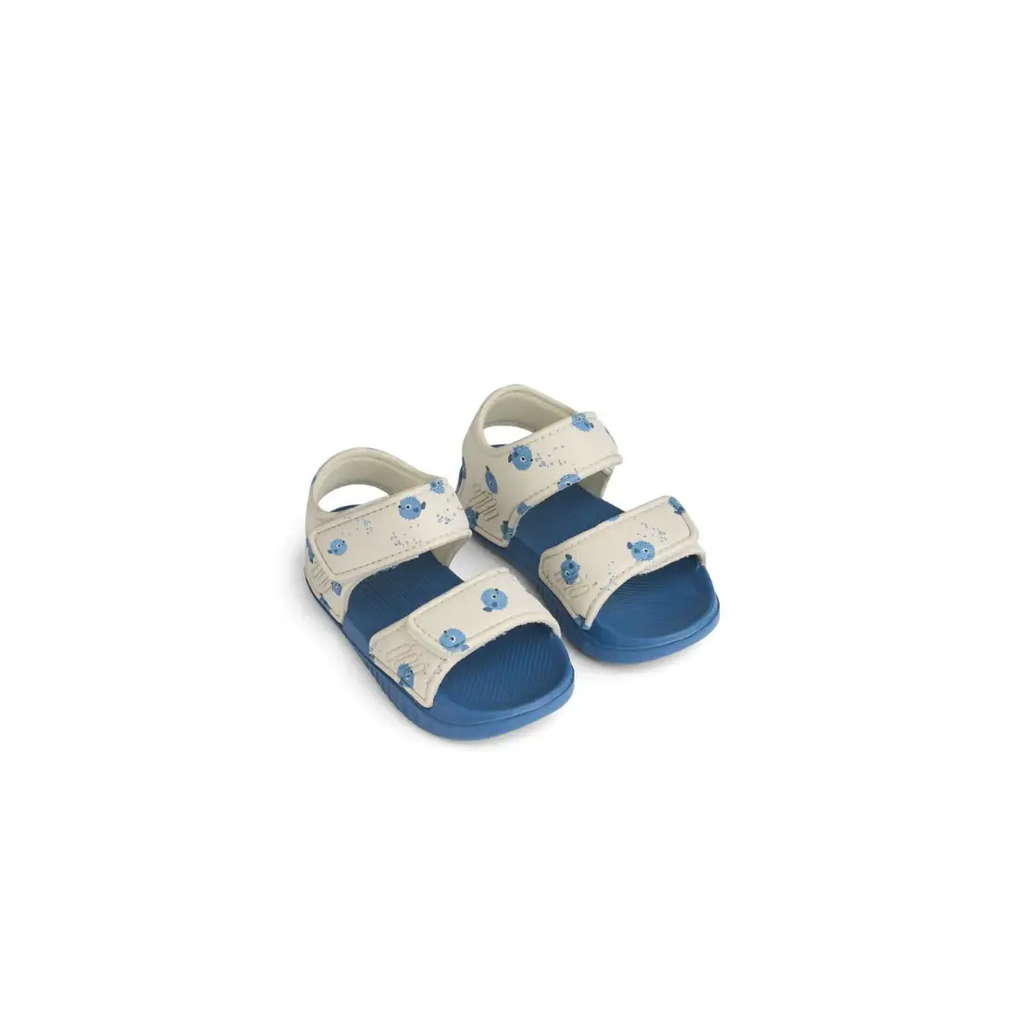 Pair of LIEWOOD Blumer baby sandals in cream with blue pufferfish print and blue sole