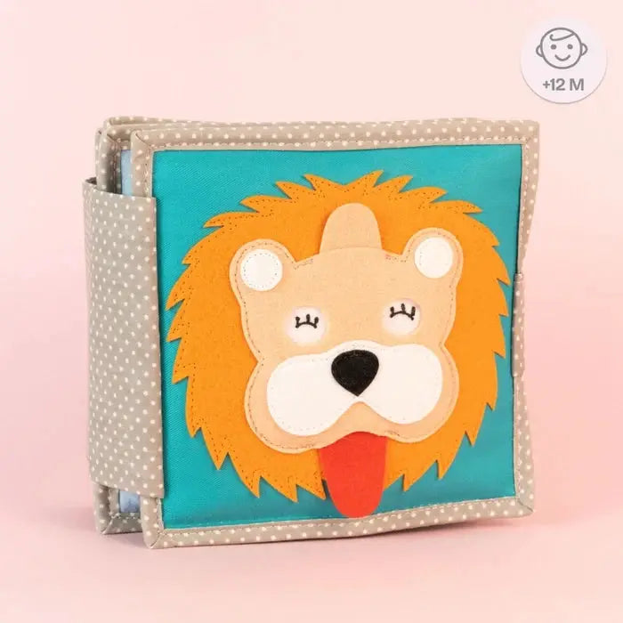 Livre d’éveil JOLLY DESIGNS pour bébé, lion en appliqué sur panneau turquoise, bord beige à pois.