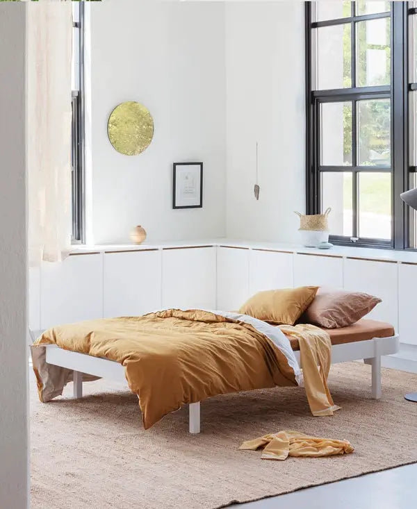 Platform bed OLIVER FURNITURE WOOD lounger 120 blanc with white frame and orange bedding in bright room