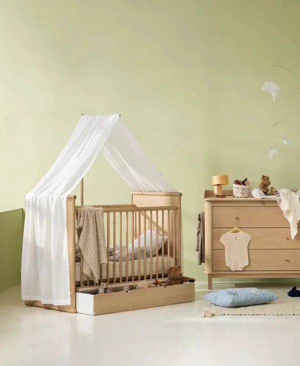 Ciel de lit bébé Camp Novel, voile transparente blanche sur lit en bois clair