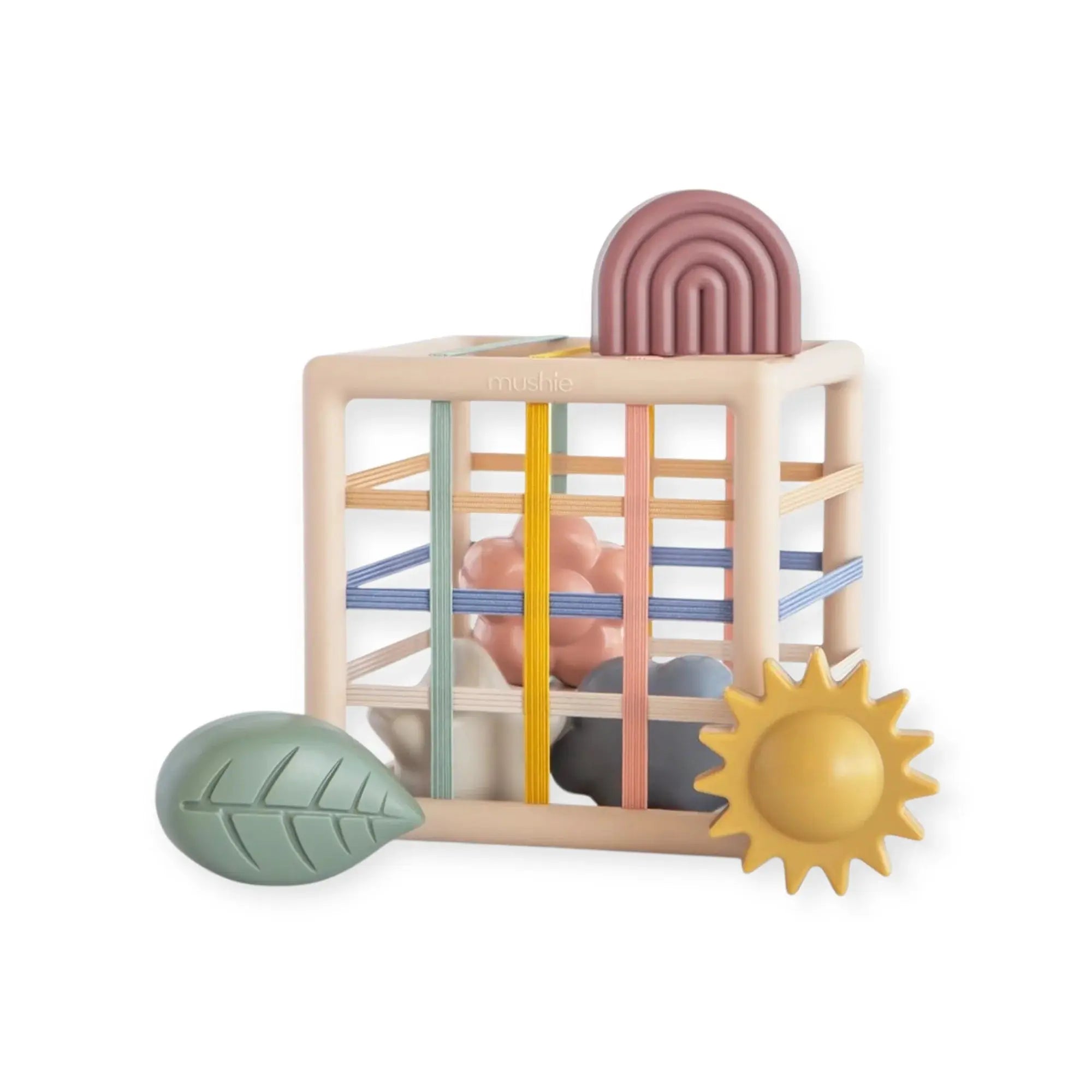 Mushie boîte à formes et élastiques sur cadre en bois pastel avec arc rose et bandes colorées