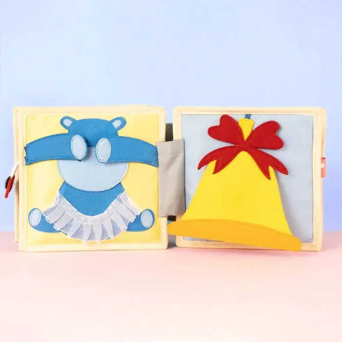 JOLLY DESIGNS livre d'éveil bébé, Citron Grenadine: 2 pages avec ours bleu et chapeau jaune.