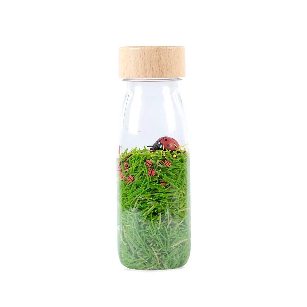 Bouteille sensorielle Petit Boum en verre avec bouchon en bois, herbe verte et coccinelles – Citron Grenadine