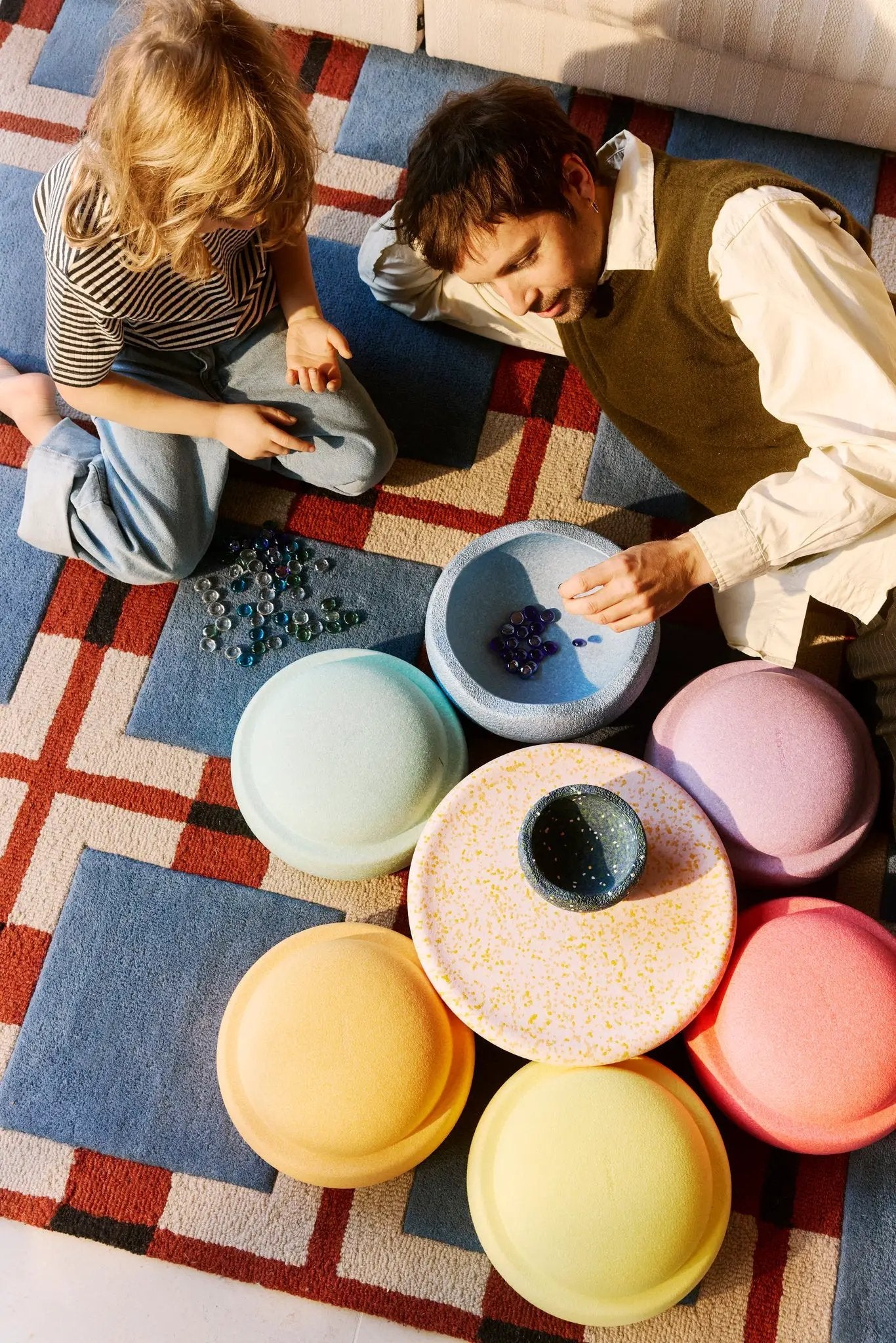 Stapelstein rainbow water lily set – pastel stackable discs for activity toys on a colorful rug