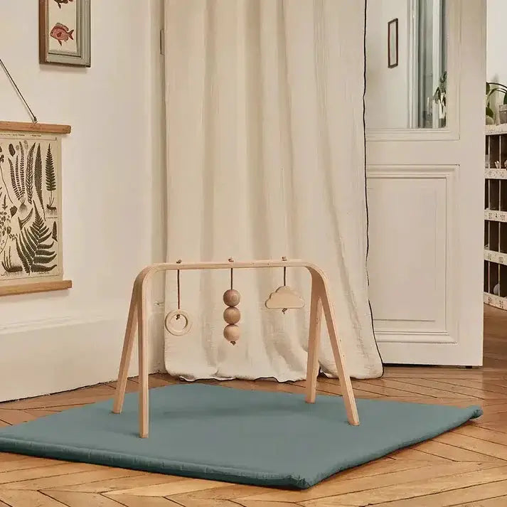 Charlie Crane TAMI baby play mat in orage blue with wooden arch and 3 hanging toys on a teal mat