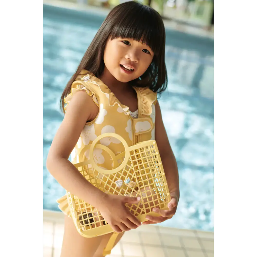 LIEWOOD dove swim vest with flower lemon yellow pattern worn by smiling girl by pool