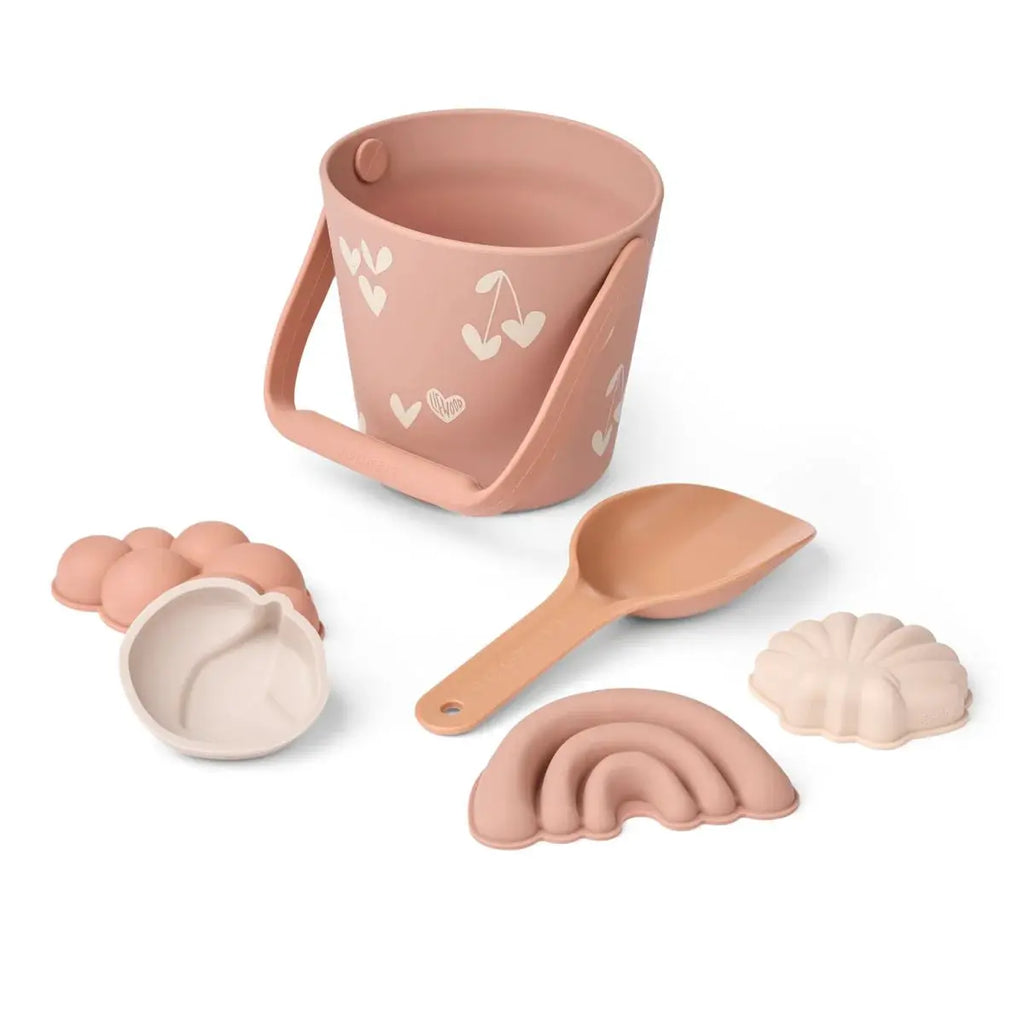 Beach toy set Liewood Gilma in pale tuscany: peach bucket with white heart prints, scoop, rainbow and shell molds.