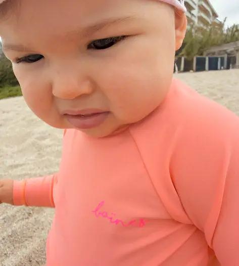 Baïnes mango maillot UPF50 in sunny peach; infant swimsuit with pink Citron Grenadine logo on chest.