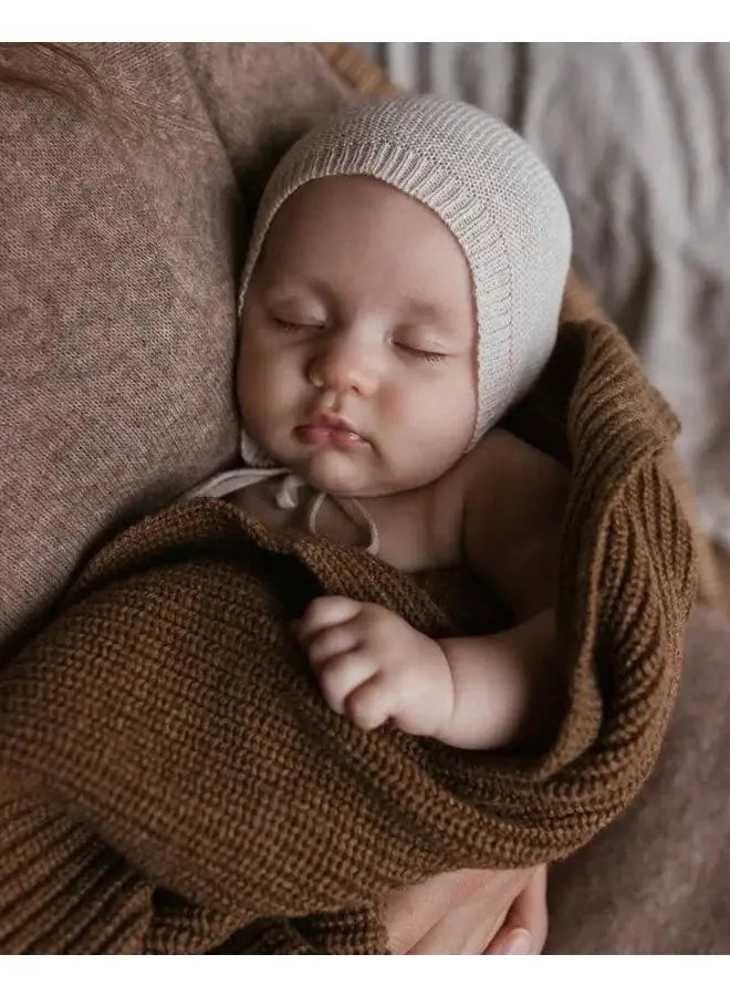 HVID bonnet dolly cream knit baby hat by Citron Grenadine on sleeping infant wrapped in brown knit blanket
