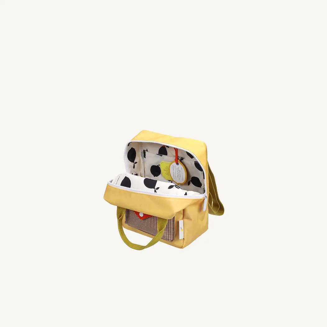 Sac à dos scolaire jaune Citron Grenadine, intérieur imprimé noir sur blanc, poche frontale à carreaux.