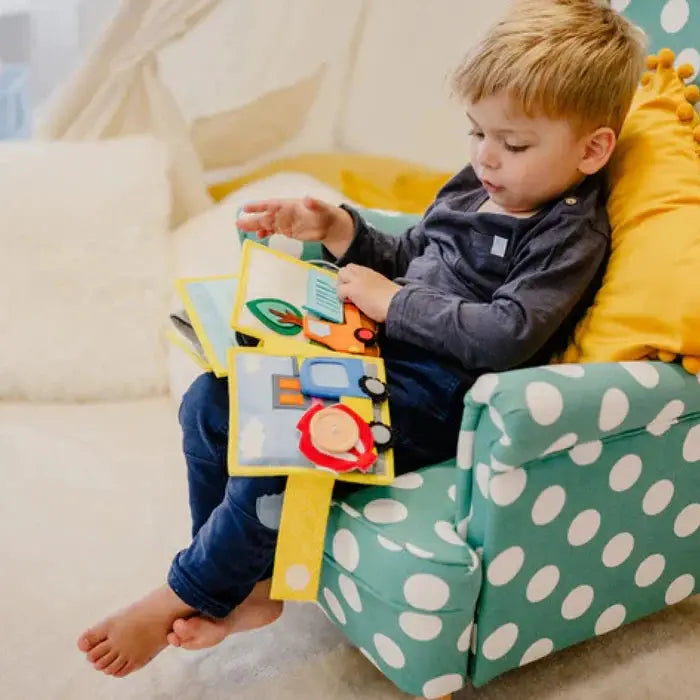 JOLLY DESIGNS livre d'éveil my first digger 18m+, enfant tient livre coloré sur fauteuil vert à pois blancs