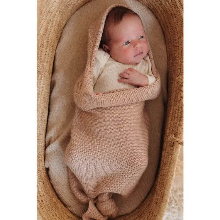 HVID cocoon apricot knit swaddling blanket wrapped around a newborn baby