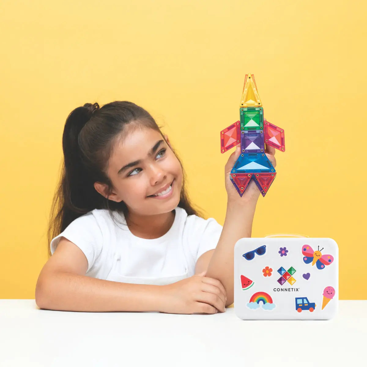 CONNETIX Travel Mini Pack 32 pc colorful translucent building blocks; child builds a rocket-shaped tower.