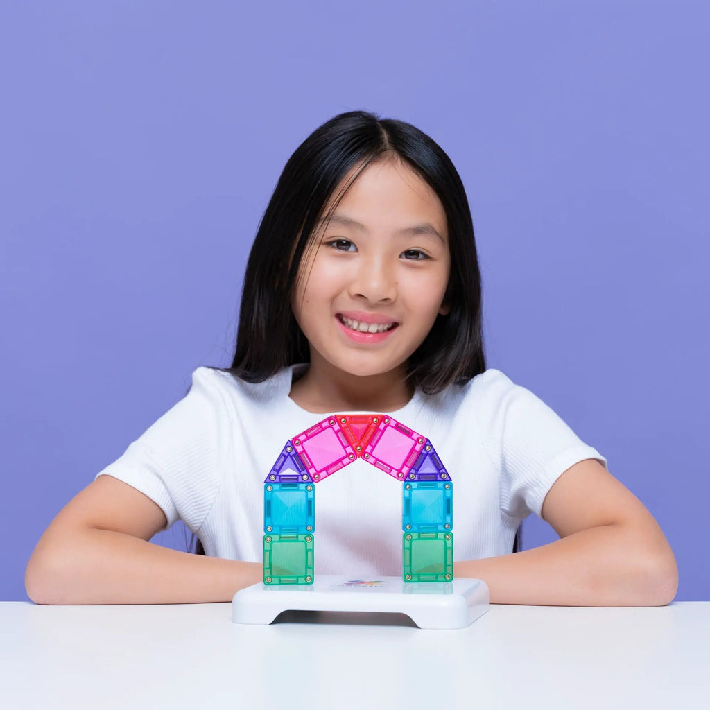 Connetix Travel Mini Pack 32 pc magnetic construction tiles in rainbow colors forming a colorful arch on a girl