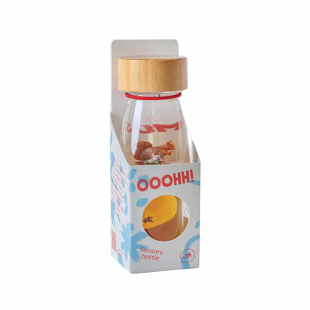 PETIT BOUM sensory bottle autumn by Citron Grenadine; clear glass bottle with wooden cap and orange contents.