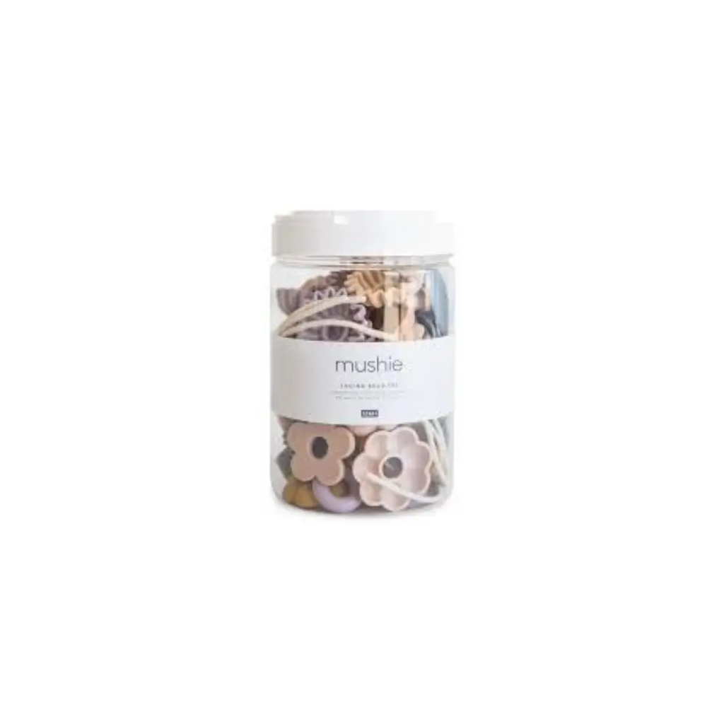 Mushie threading beads jar with pastel flower beads; clear container, white lid, beading kit for ages 18 months