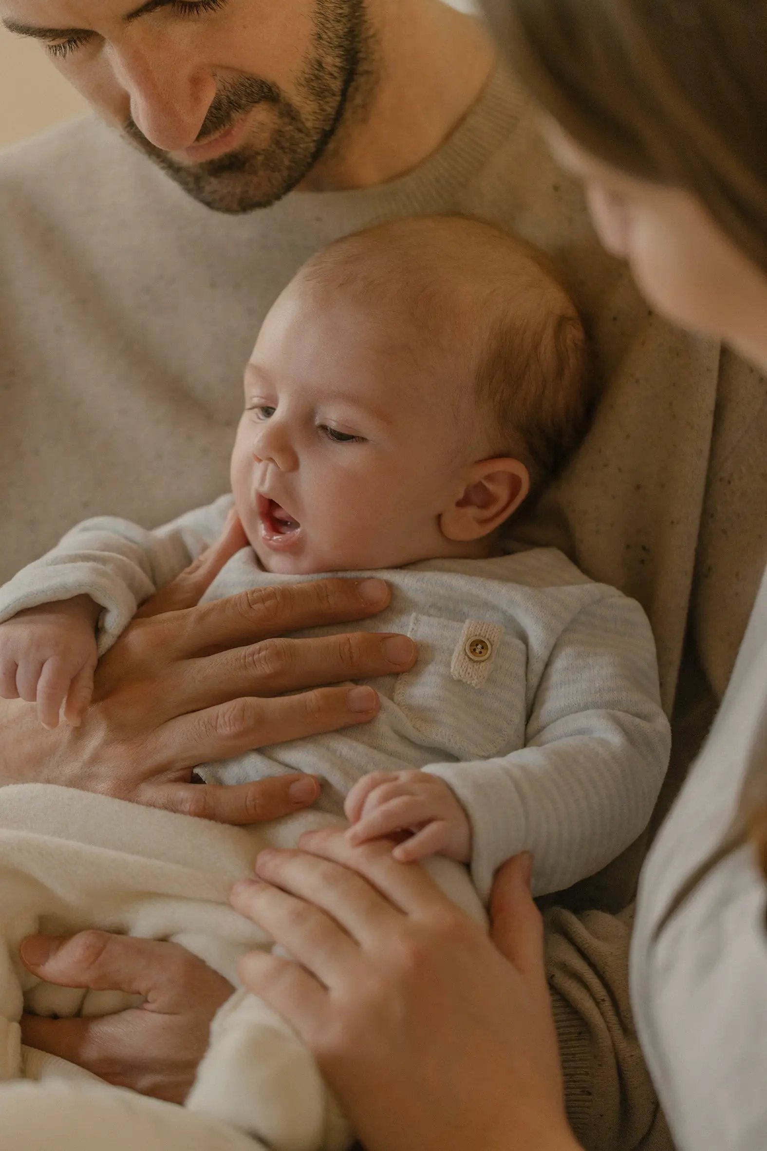 Belfort pull in ciel by Citron Grenadine; infant held by parents in soft knit.