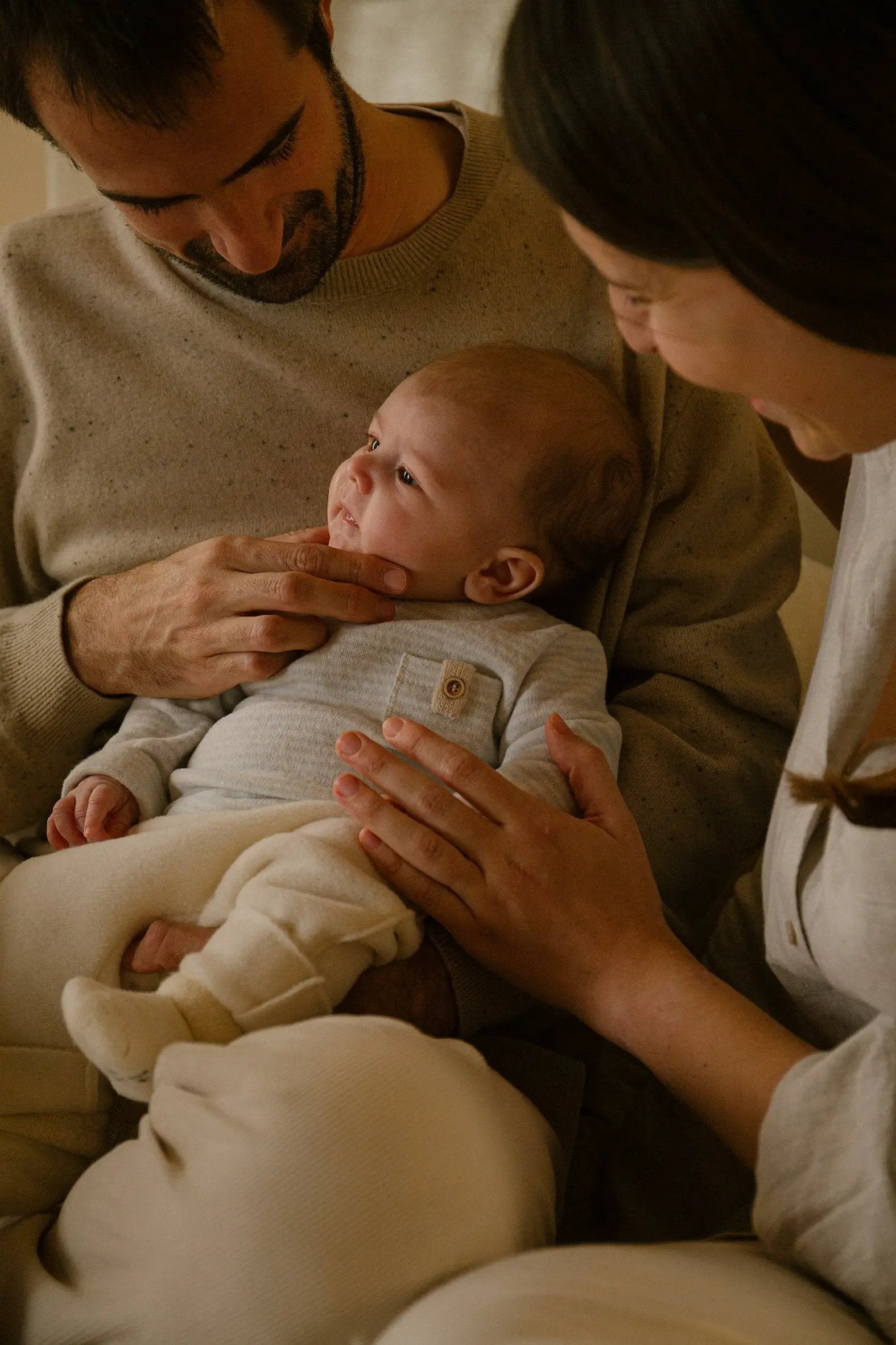 Belfort pull beige knit sweater worn by a couple cradling a baby