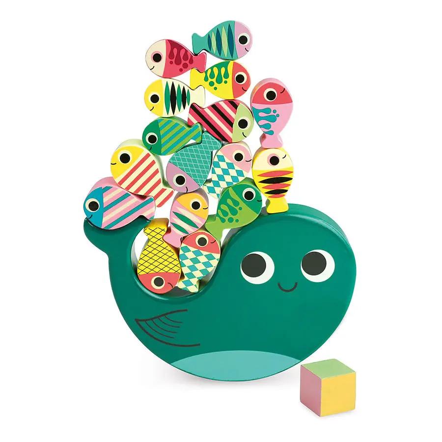 Whale-shaped dexterity game with colorful stacked fish pieces and a pastel cube