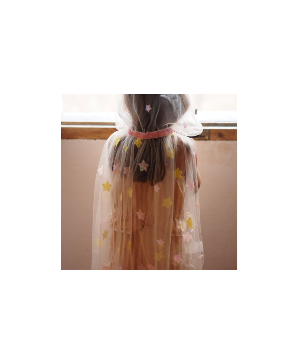 RATATAM cape lily with yellow and pink stars; sheer cape over pink dress