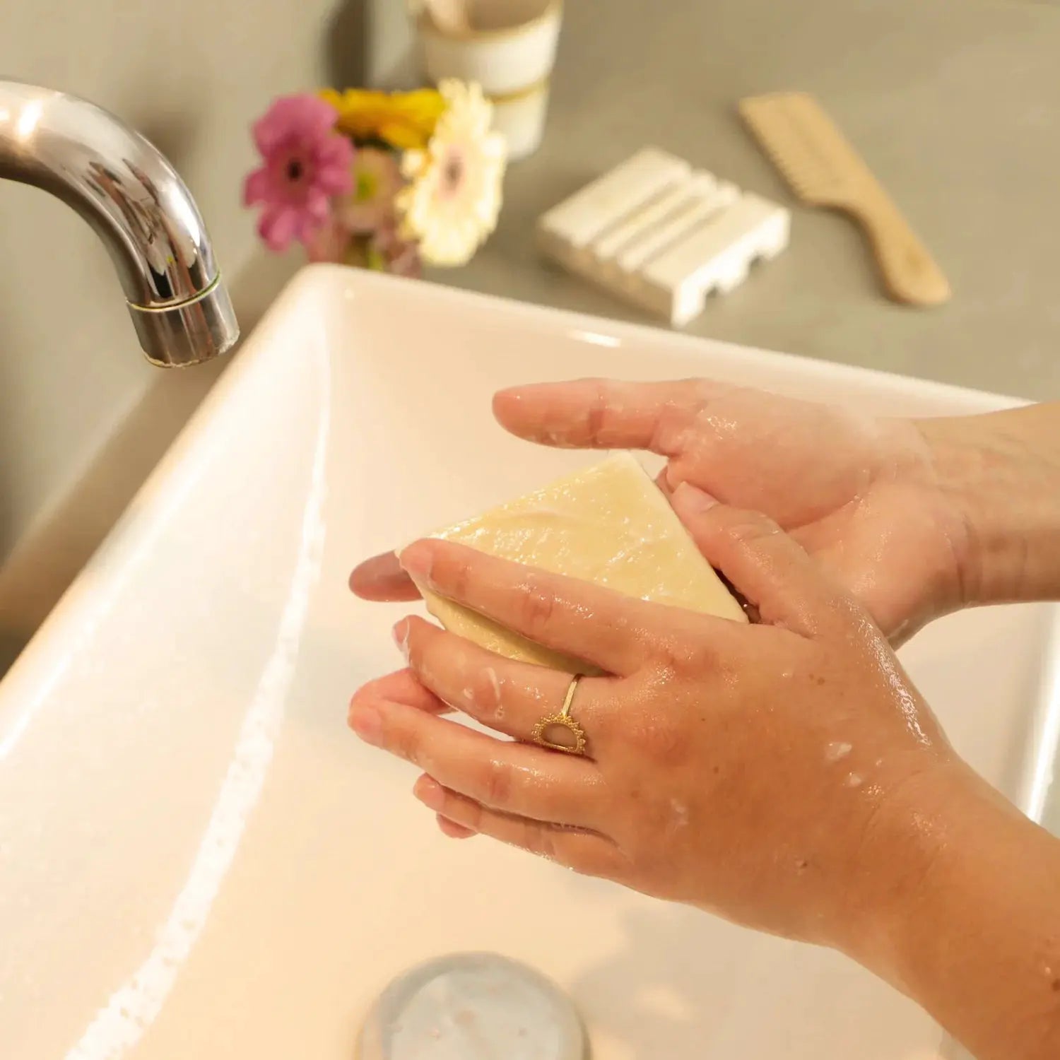 COMME AVANT Savon à l'huile d'olive solid soap bar being lathered under running water in sink